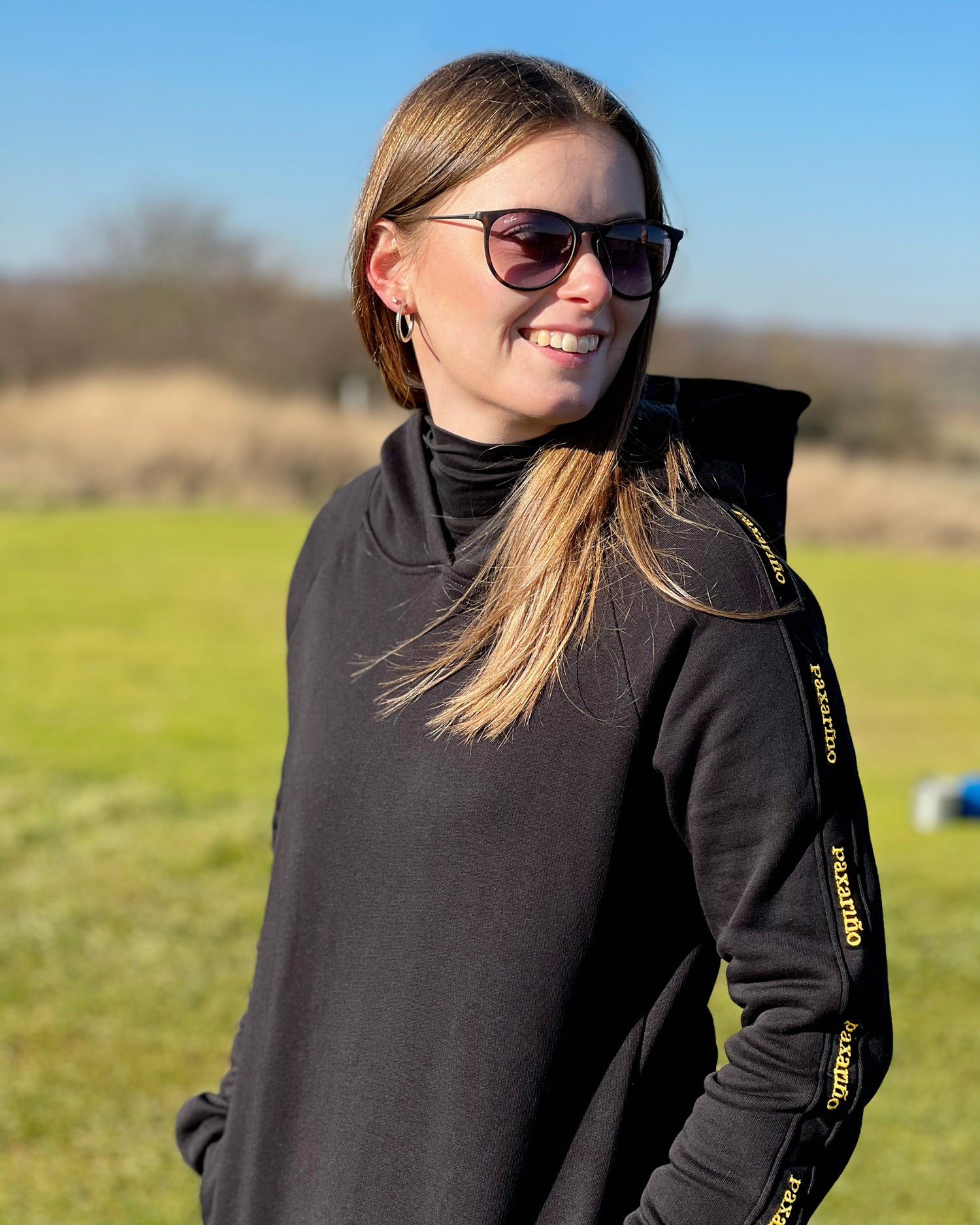 A girl wearing the Organic Golf Hoodie from paxariño on the golf course