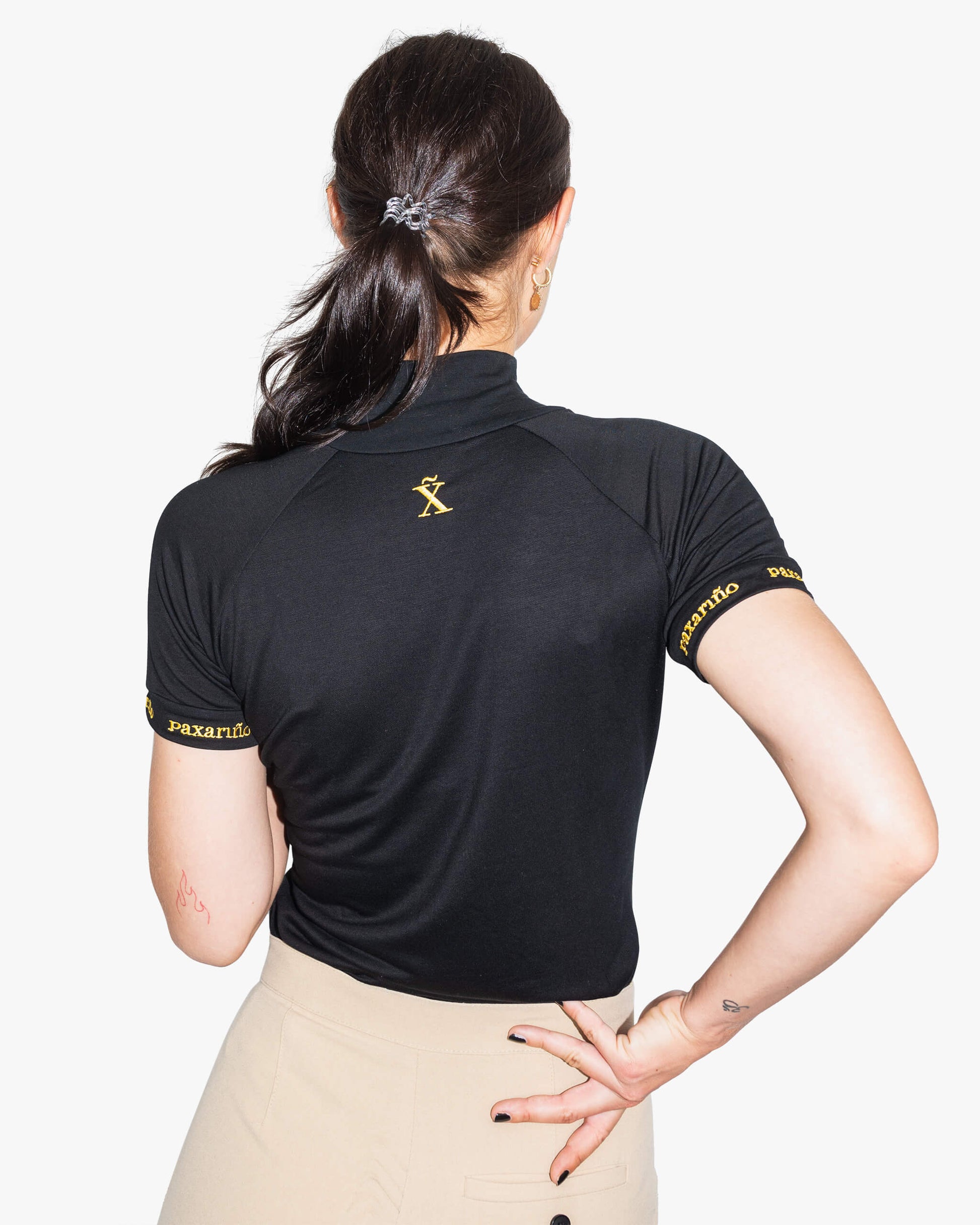 Rückansicht schwarzes Golf Shirt aus TENCEL™ für Damen von paxariño.